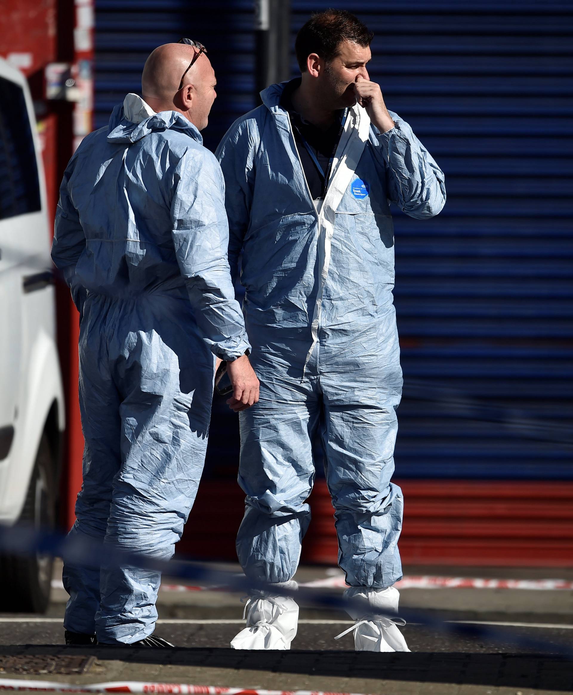 Forensic investigators stand behind cordon tape at the scene of an attack where a man drove a van at muslim worshippers outside a mosque in Finsbury Park in North London