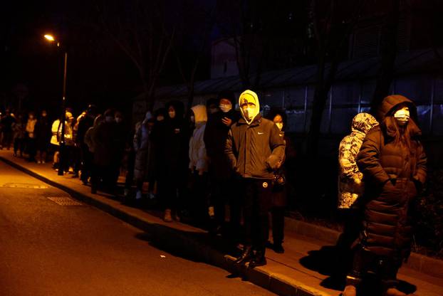 People line up to take a nucleic acid test for the coronavirus disease (COVID-19), near a residential compound in Beijing