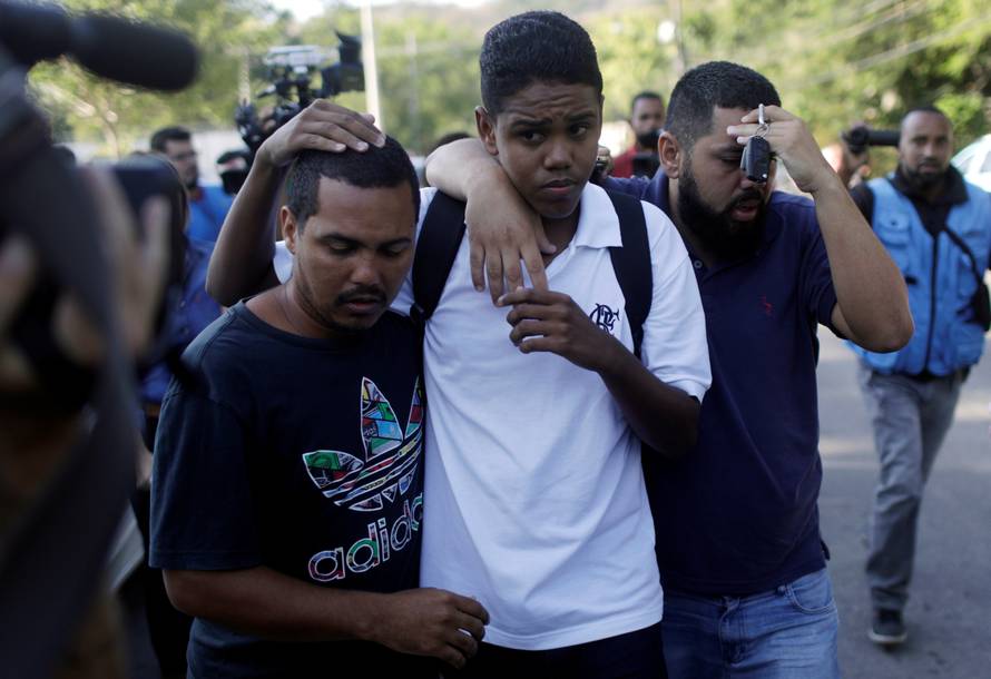 People embrace in front of Flamengo training center after deadly fire in Rio de Janeiro