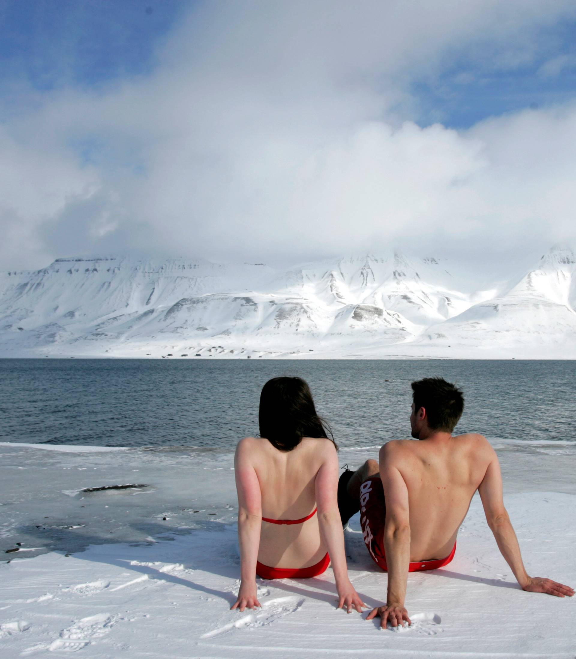 FILE PHOTO: Climate activists Lesley Butler and Rob Bell "sunbathe" on the edge of a frozen fjord in the Norwegian Arctic town of Longyearbyen