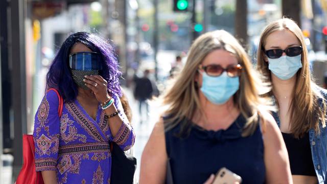 FILE PHOTO: People wearing face protective masks walk on Hollywood Blvd during the outbreak of the coronavirus disease (COVID-19), in Los Angeles