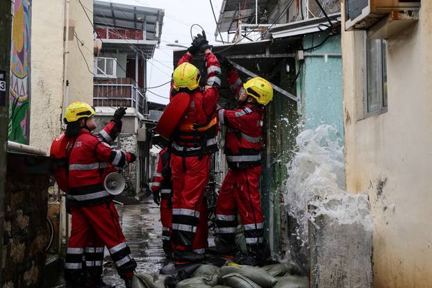 Firefighters secure a loose cable damaged by Super Typhoon Ragasa in Hong Kong