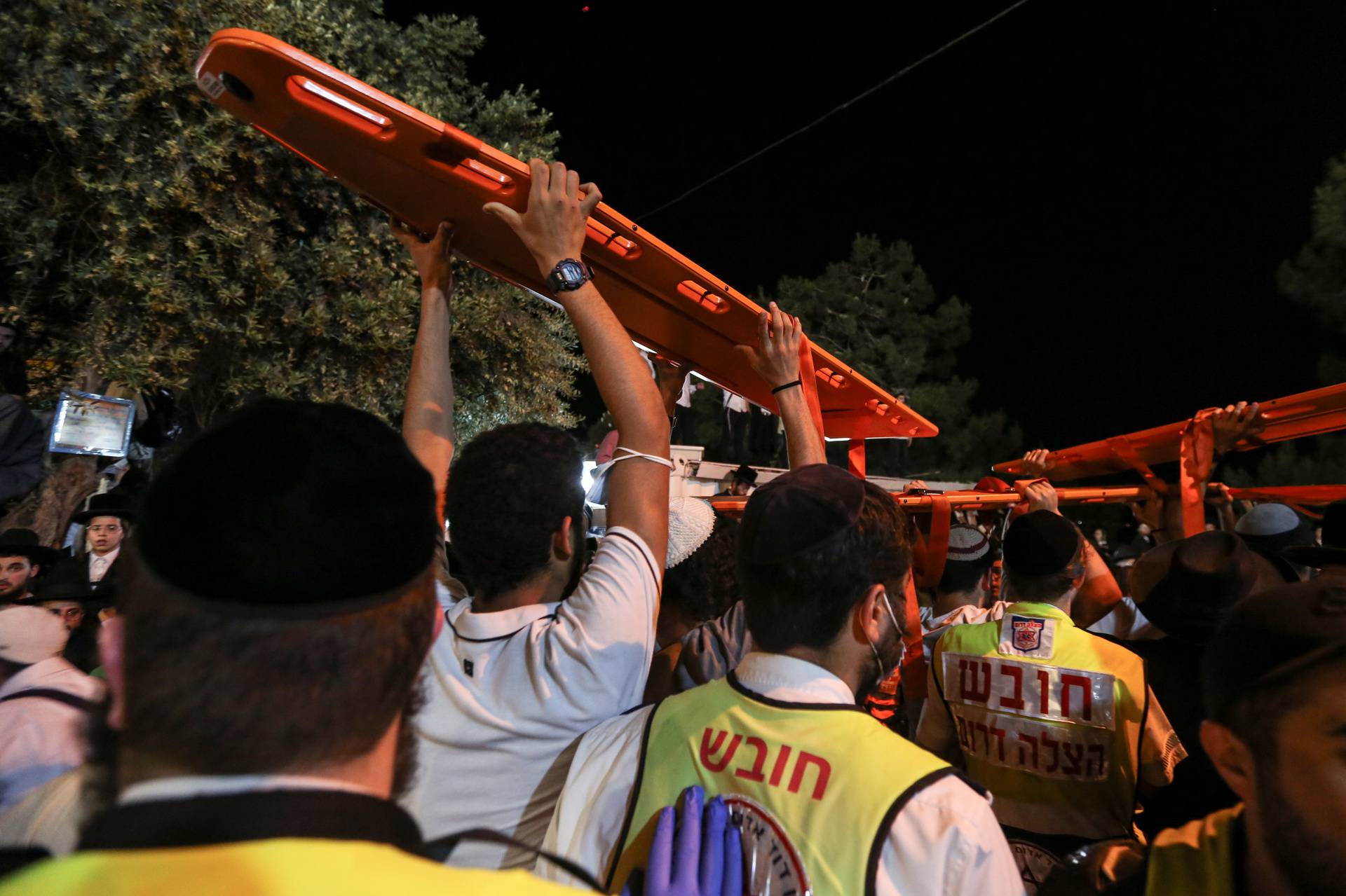 Medics and rescue workers carry stretchers at the Lag B'Omer event in Mount Meron, northern Israel, where fatalities were reported among the thousands of ultra-Orthodox Jews gathered