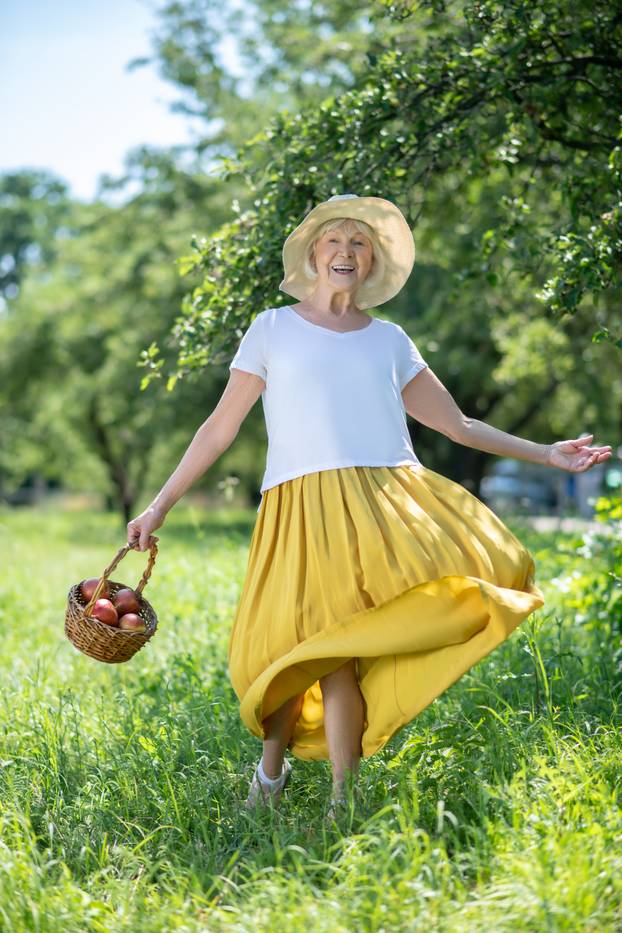 Active elderly woman enjoying summer in the garden