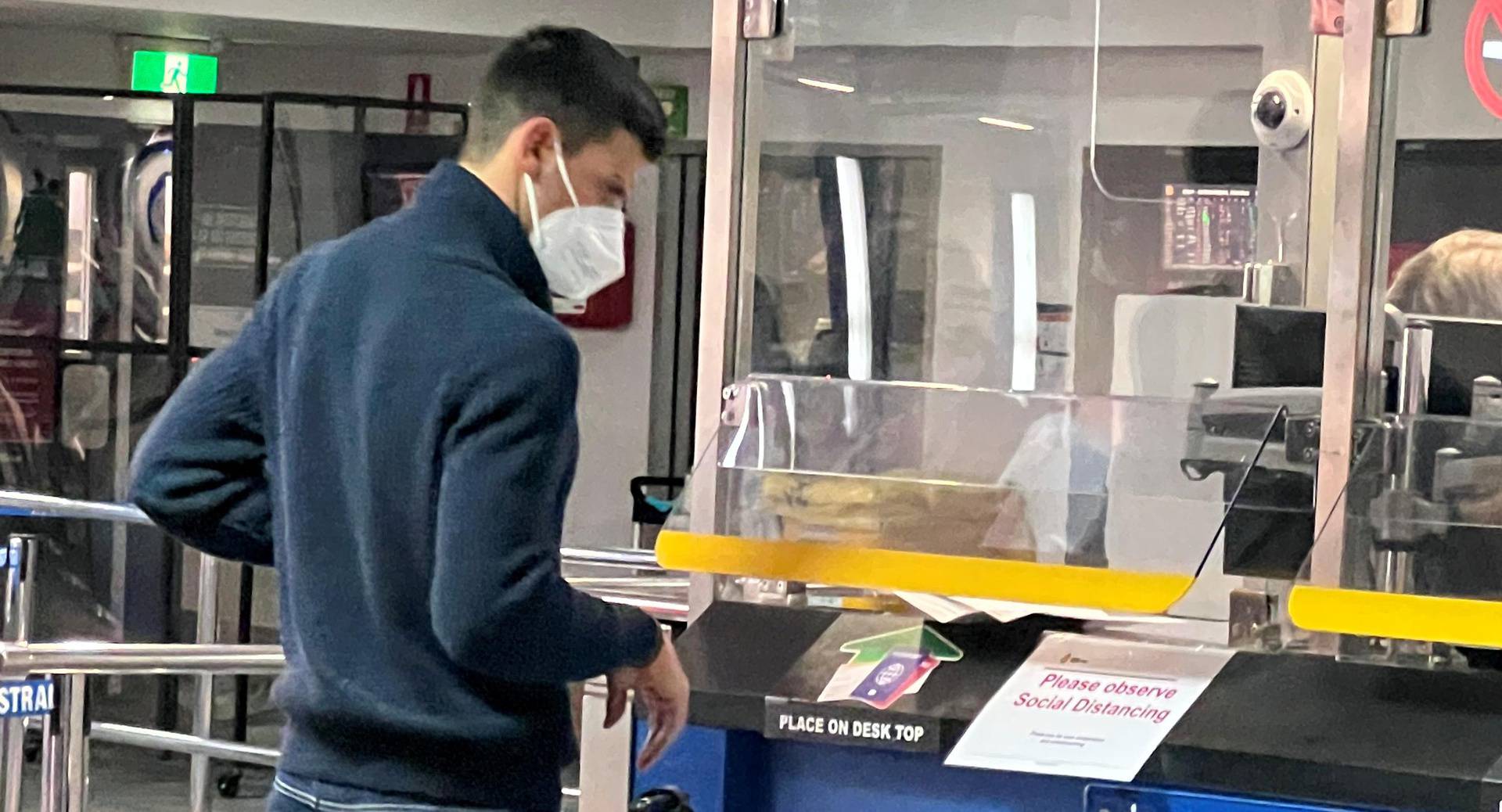 Serbian tennis player Novak Djokovic stands at a booth of the Australian Border Force at the airport in Melbourne