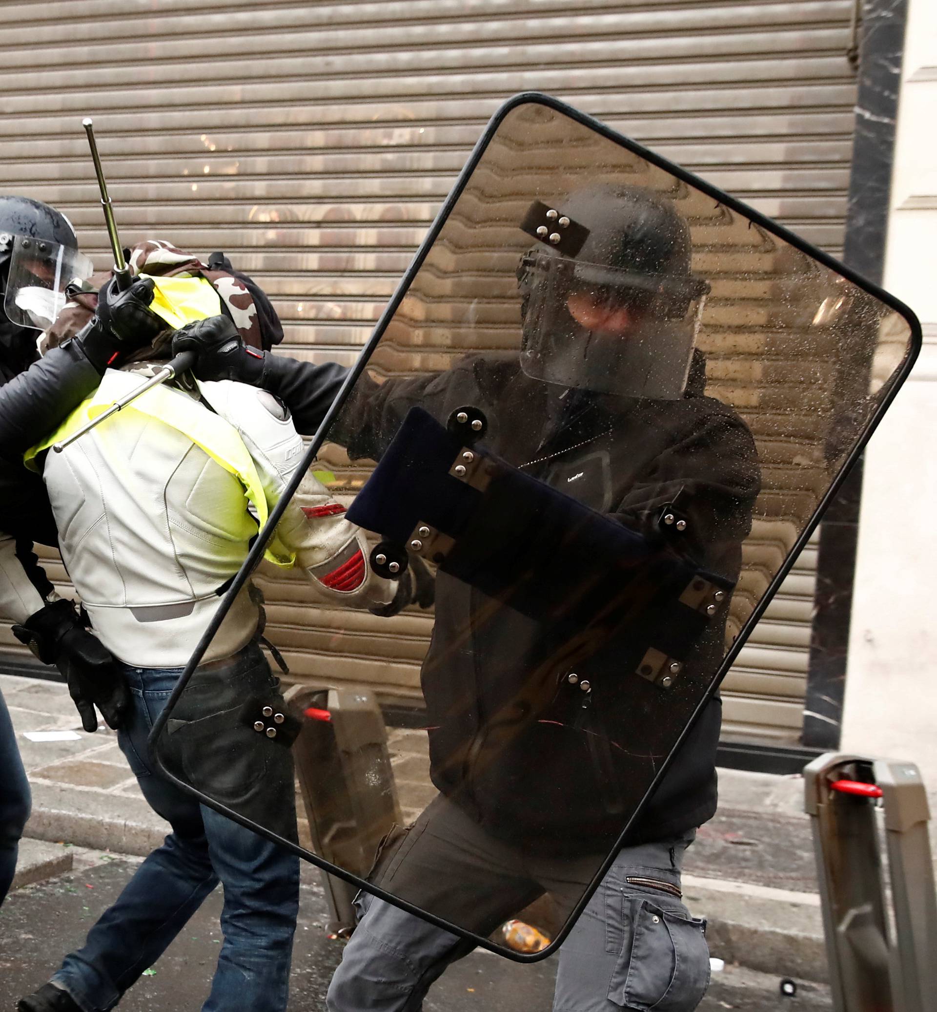 French police apprehend a protester wearing a yellow vest during clashes with police during a national day of protest by the "yellow vests" movement in Paris