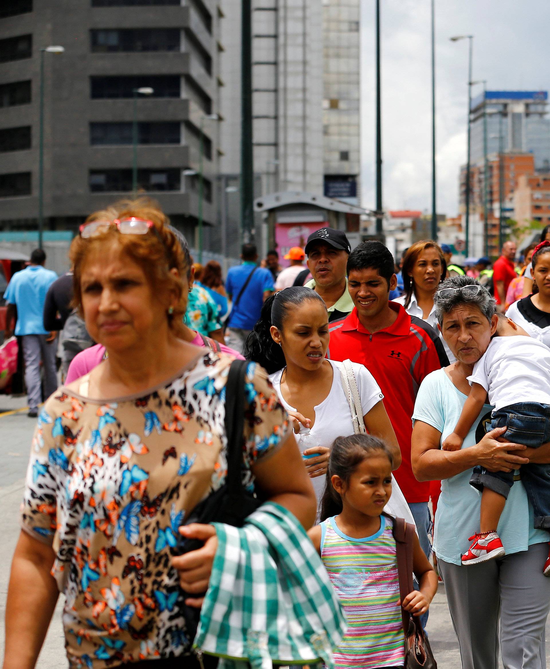 People line up expecting to buy food outside a supermarket in Caracas