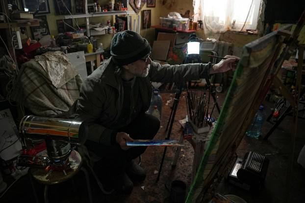 Ukrainian artist works at his studio during a power blackout in Kyiv