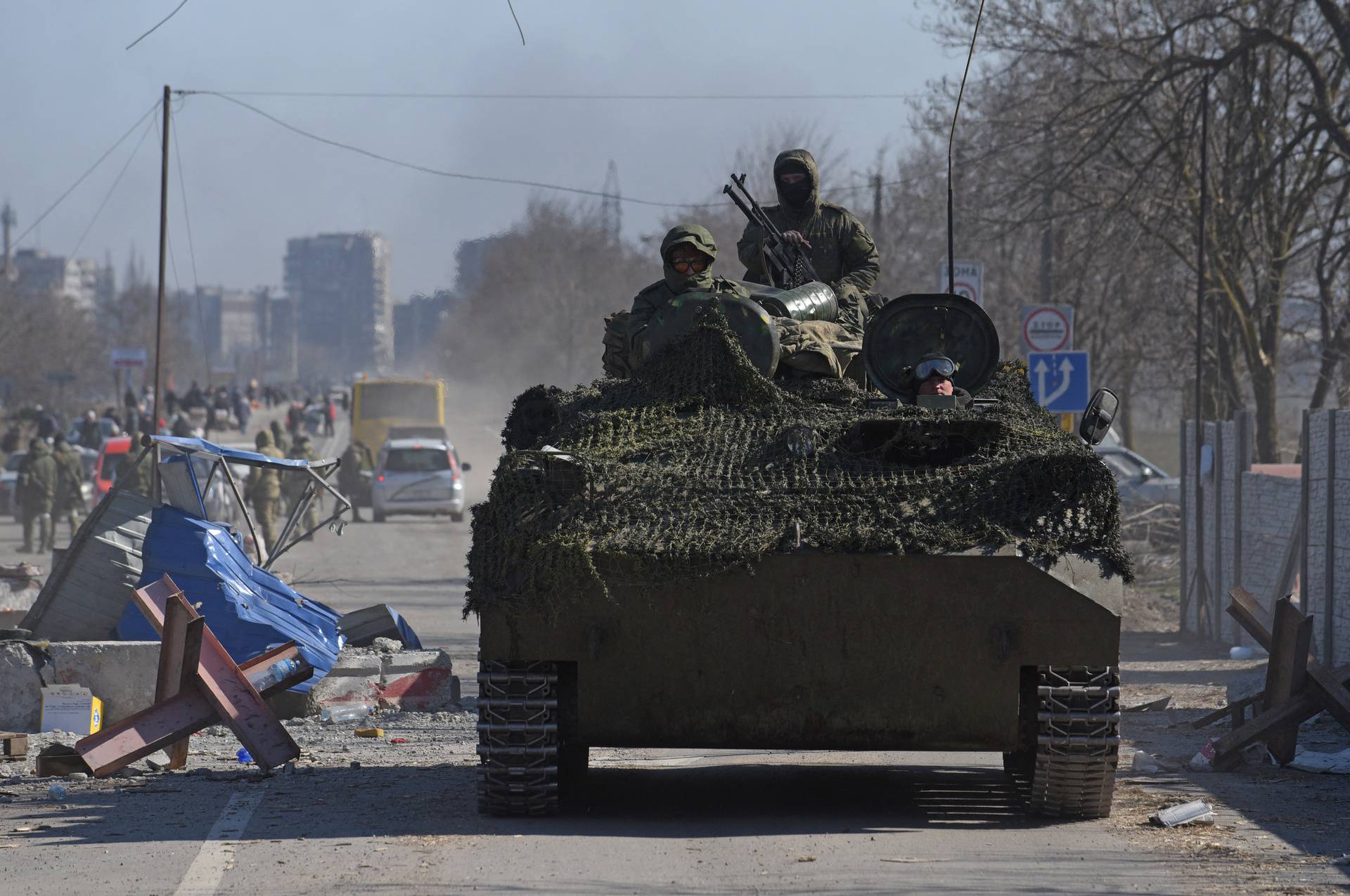 Service members of pro-Russian troops drive an armoured vehicle in the besieged city of Mariupol