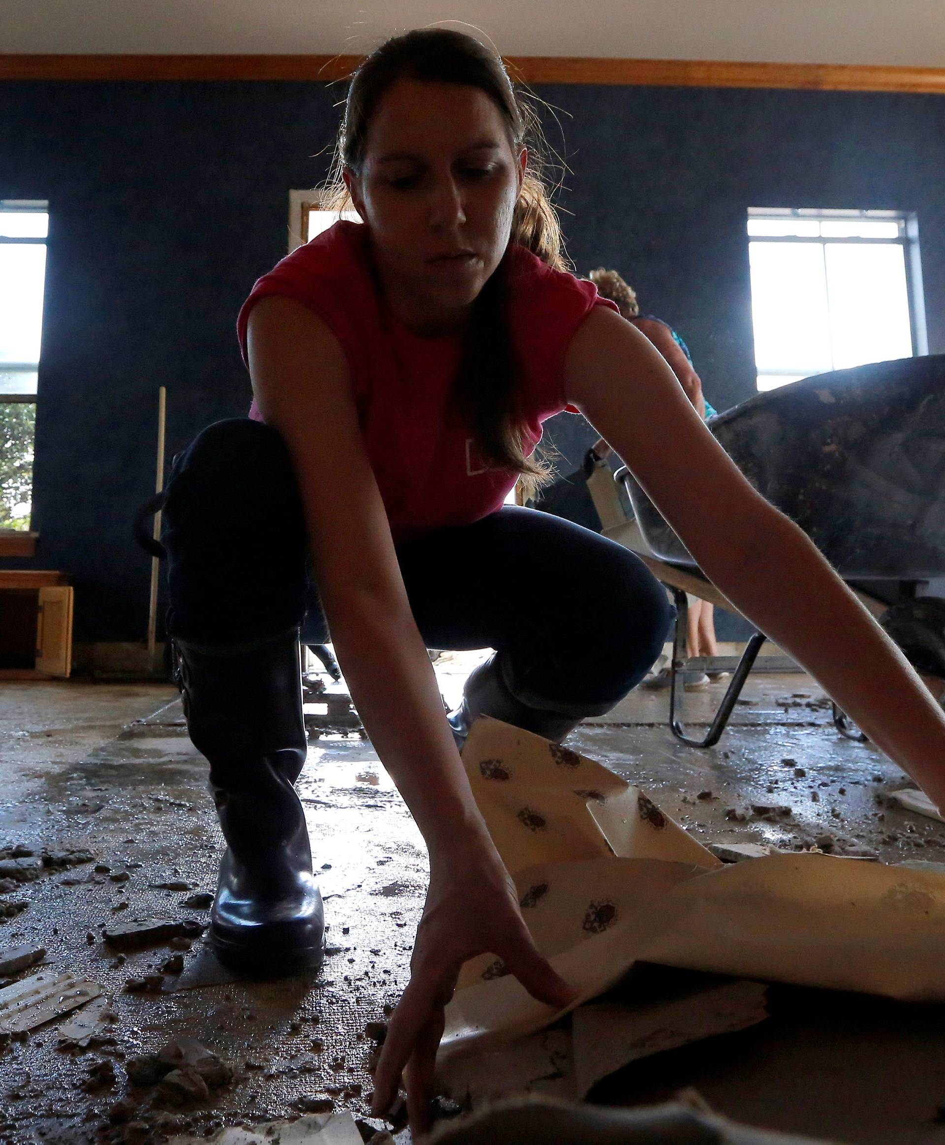 Brittany Bogan removes drywall from her family's business after flooding occurred in Denham Springs