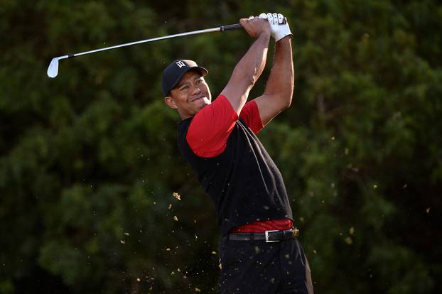 FILE PHOTO: Tiger Woods plays his shot from the 11th tee during the final round of the Farmers Insurance Open golf tournament at Torrey Pines Municipal Golf Course in San Diego