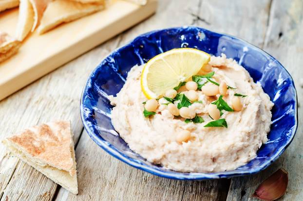 White,Beans,Hummus,With,Lemon,On,White,Wood,Background.,Toning.