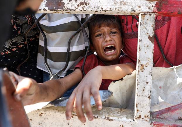 Palestinians receive food from charity kitchen, in Gaza City