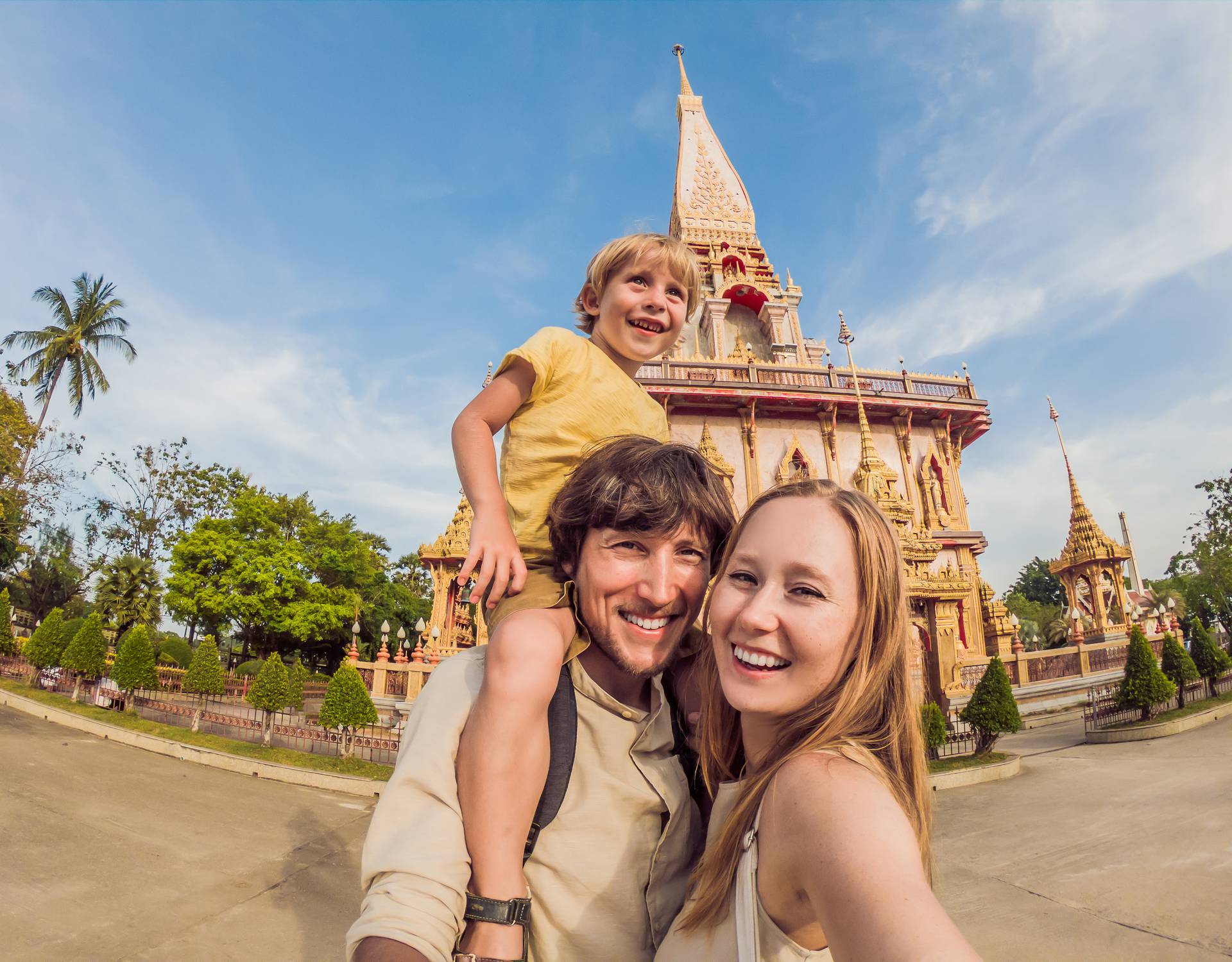 A happy family of tourists on the background of Wat Chalong in Thailand. Traveling with children concept