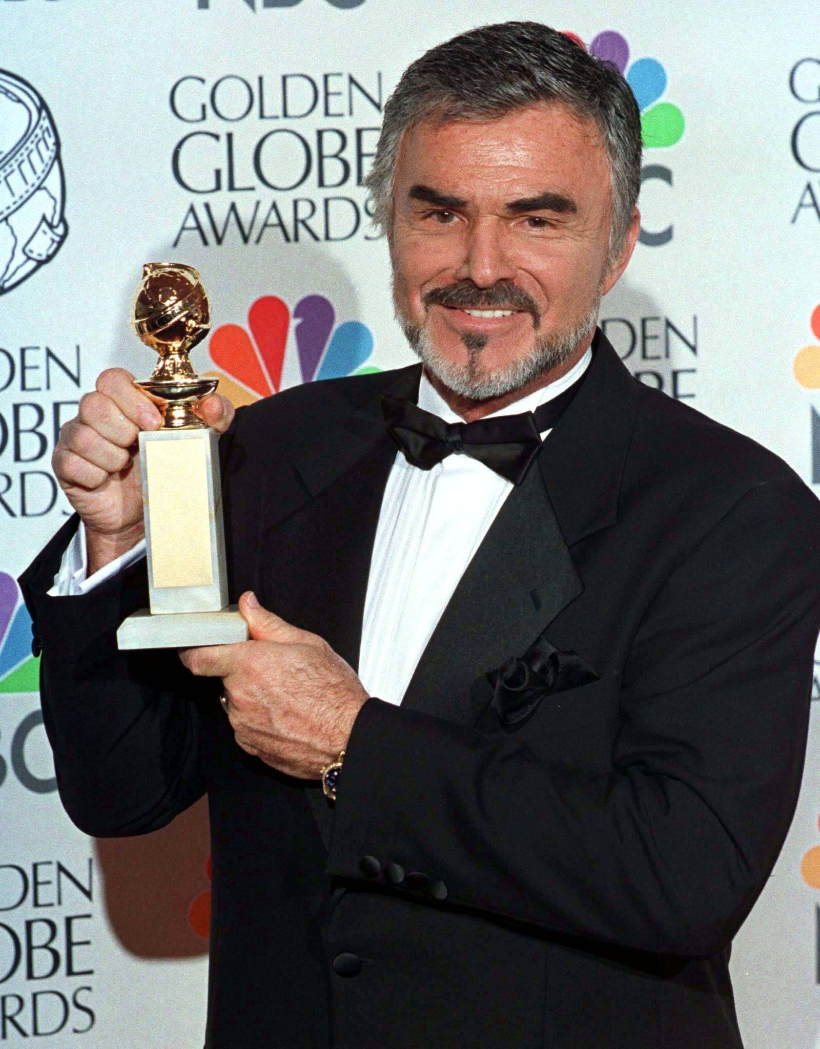 FILE PHOTO: Burt Reynolds holds his Golden Globe award won for best supporting actor in a motion picture for "Boogie Nights" at the 55th annual Goden Globe Awards in Beverly Hills