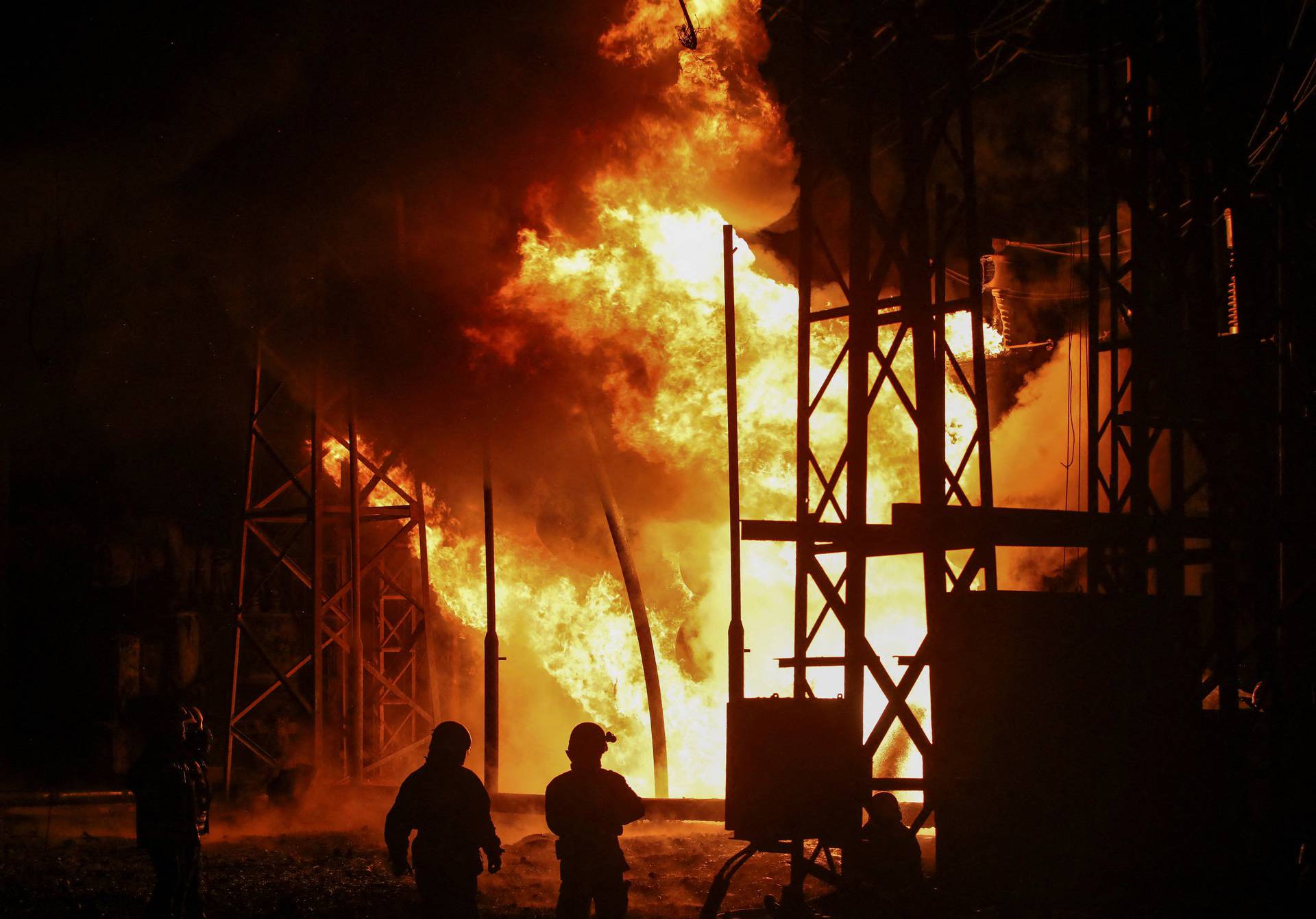 Firefighters work at a site of a thermal power plant damaged by a Russian missile strike in Kharkiv