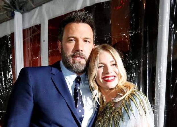 Director and cast member Affleck poses with cast member Miller at the premiere of "Live by Night" in Hollywood