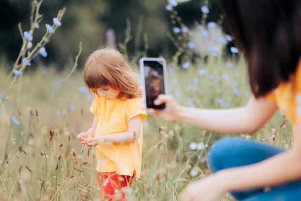 Mother,Taking,A,Picture,Of,Her,Daughter,Playing,In,Nature.