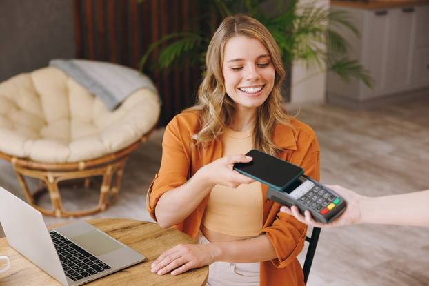 Young,Woman,Wear,Shirt,Hold,Bank,Payment,Terminal,To,Process