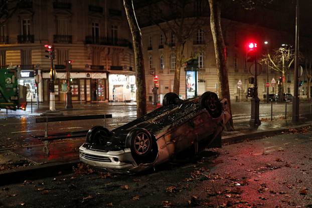 A vandalized car is seen on a street the morning after clashes with protesters wearing yellow vests, a symbol of a French drivers