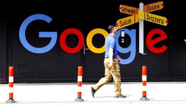 FILE PHOTO: A man walks past a logo of Alphabet Inc's Google in Zurich