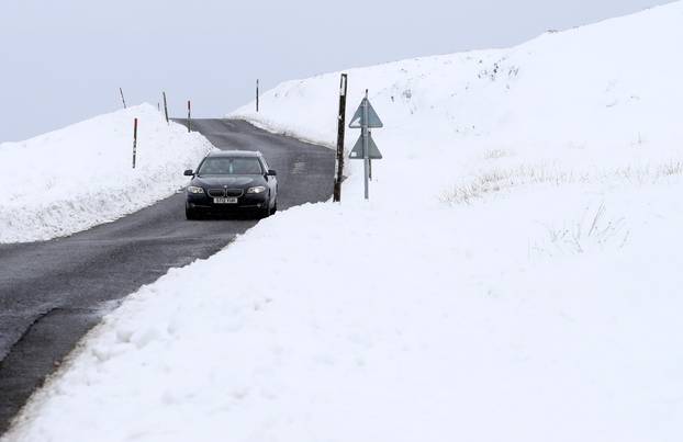 A car drives along the A924 on a snow-covered Moulin Moor near Pitlochry as storm Darcy approaches the country