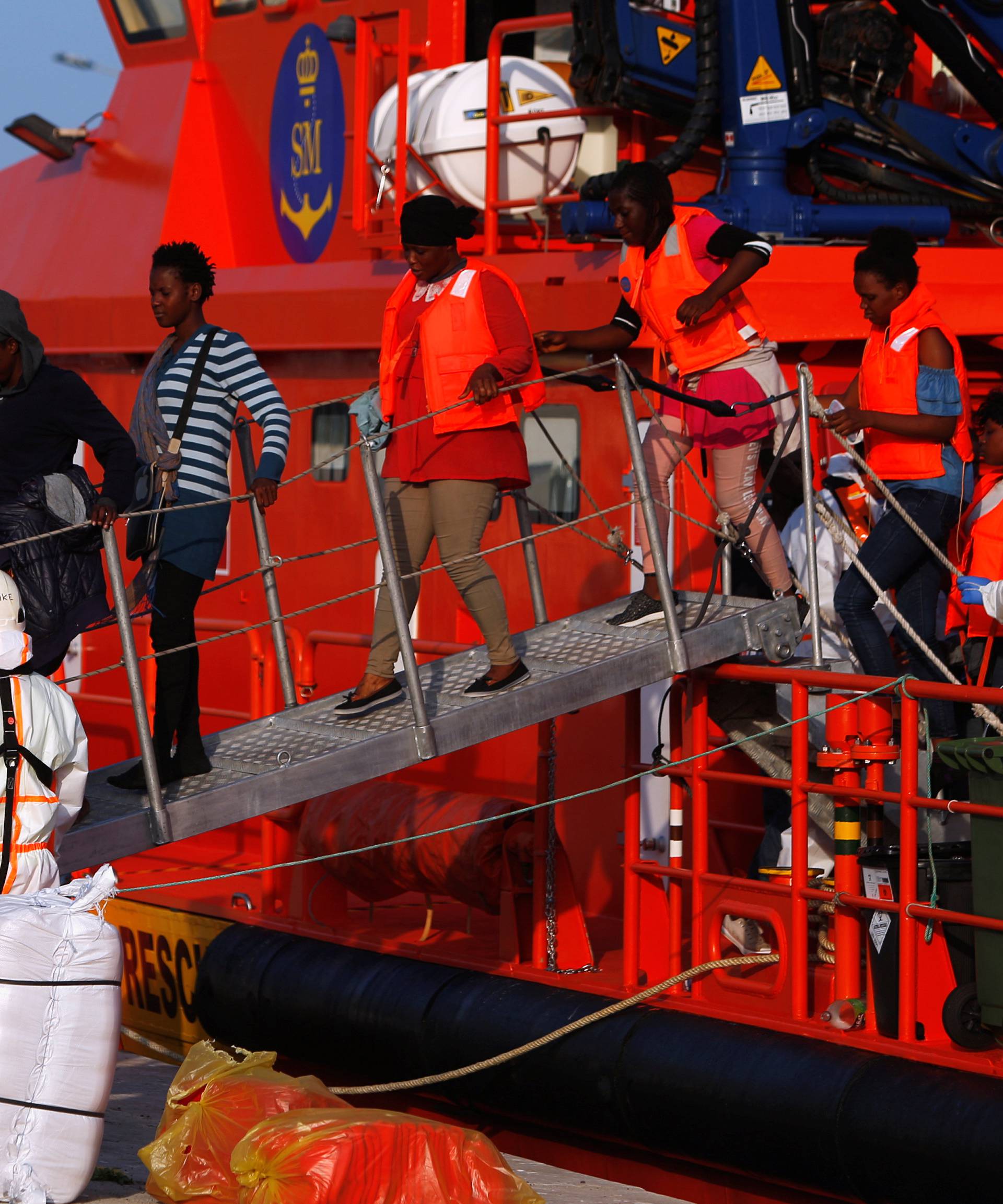 Migrant women leave a rescue boat after arriving at the port of Malaga