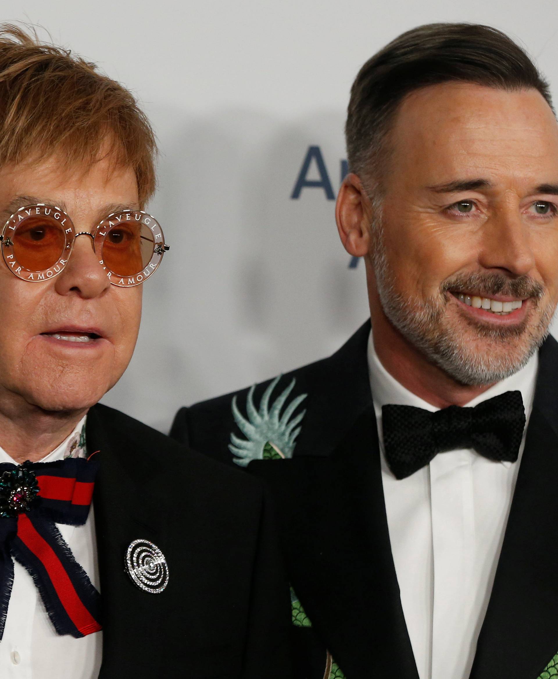 Singer Elton John and his partner David Furnish pose on the red carpet during the commemoration of the Elton John AIDS Foundation 25th year fall gala at the Cathedral of St. John the Divine in New York City