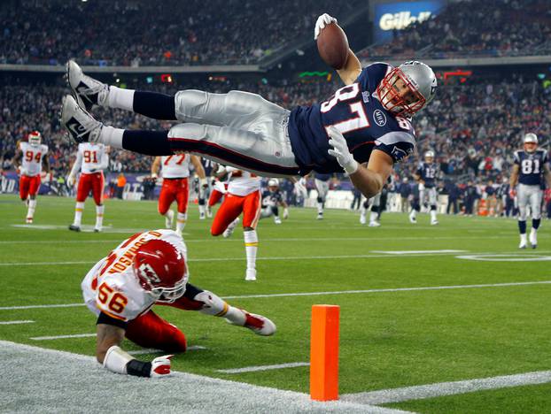 FILE PHOTO: New England Patriots tight end Rob Gronkowski (top) scores a touchdown over Kansas City Chiefs linebacker Derrick Johnson in the second half of their NFL football game in Foxborough