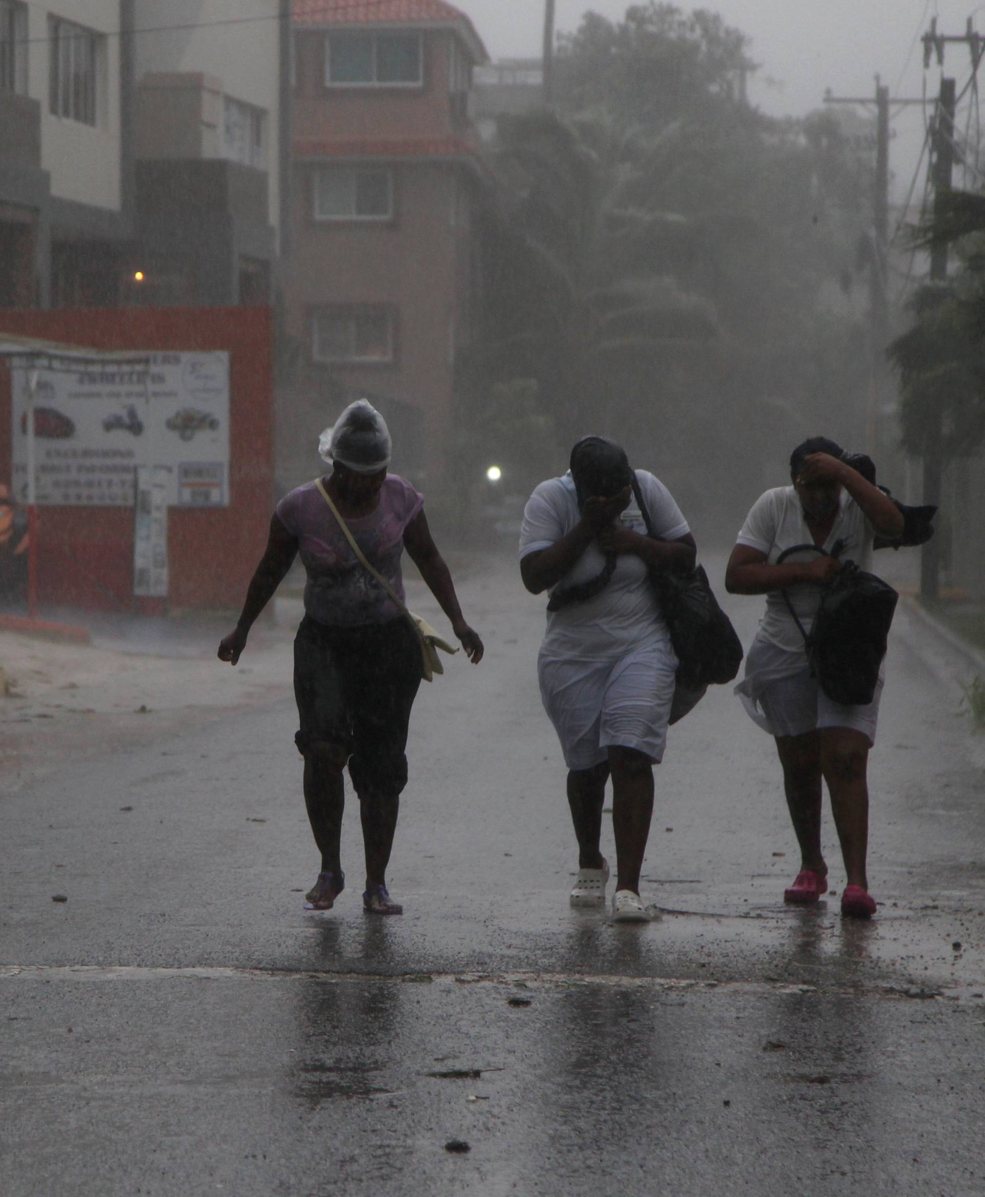Women walk against the wind before the arrival of Hurricane Maria in Punta Cana