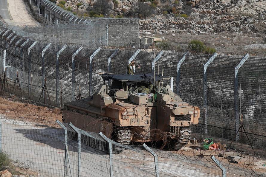 An Israeli soldier conducts morning prayers on a Namer Armoured Personnel Carrier (APC), along the Golan Heights side of the ceasefire line between Syria and the Israeli-occupied Golan Heights