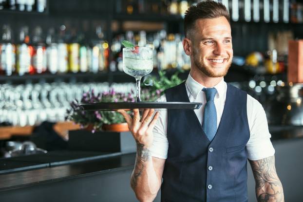 Smiling,Elegant,Waiter,Is,Holding,A,Tray,With,A,Decorated