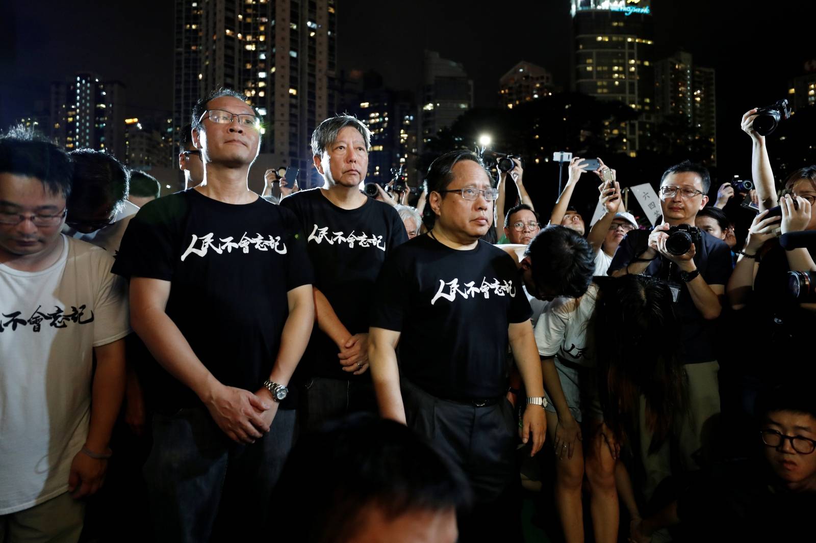 Pro-democracy activists Richard Tsoi Yiu Cheong, Lee Cheuk-yan, Albert Ho Chun-Yan pay tribute to those who died during a candlelight vigil at Victoria Park in Hong Kong