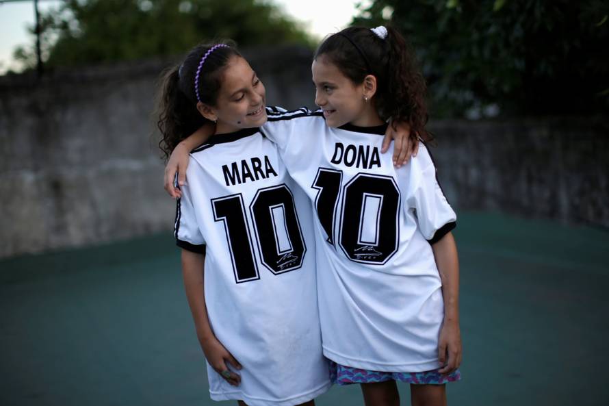 Mara and Dona, twin daughters of Walter Gaston Rotundo, a devoted Diego Maradona fan who named his daughters after the soccer star, pose for photos at their house, in Buenos Aires