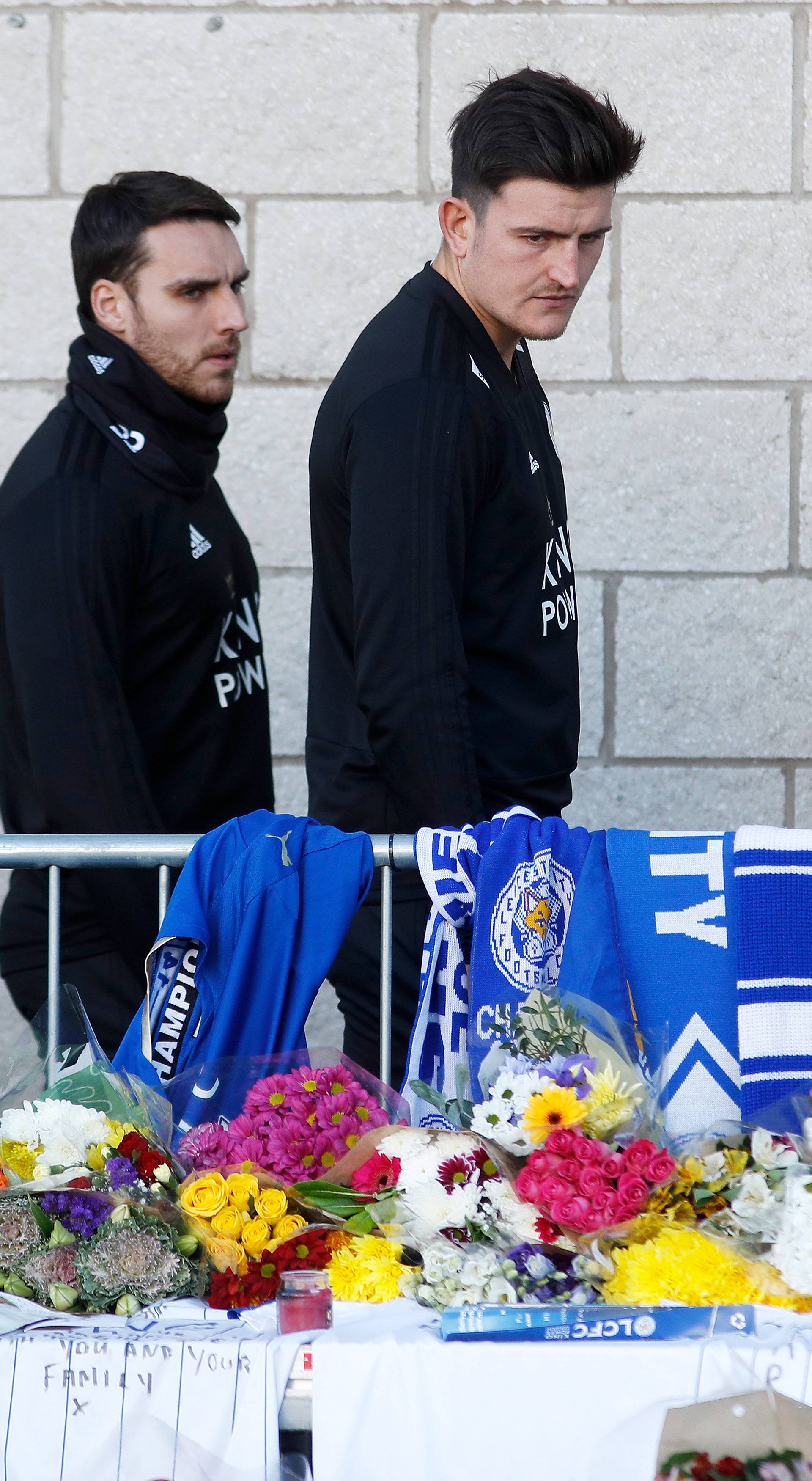 Harry Maguire and Matty James look at tributes left for Leicester City's owner Thai businessman Vichai Srivaddhanaprabha and four other people who died when the helicopter they were travelling in crashed in Leicester