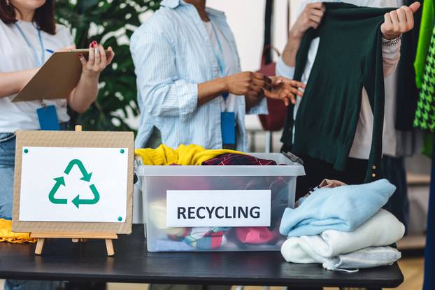 Group,Of,Volunteers,,Young,Women,And,Man,,Sorting,Clothes,In