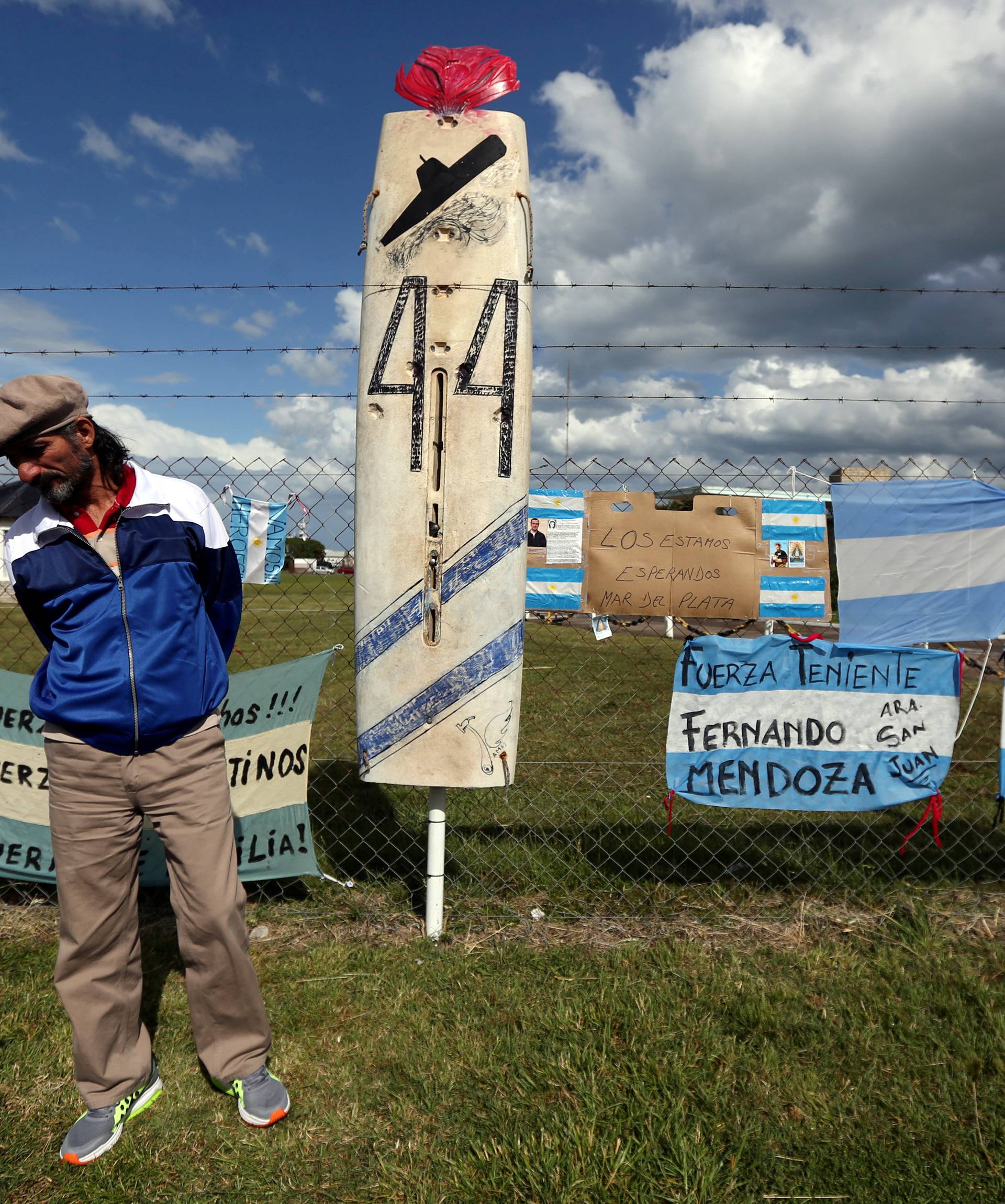 A man stands in front of signs in support of the missing crew members of the ARA San Juan submarine in Mar del Plata