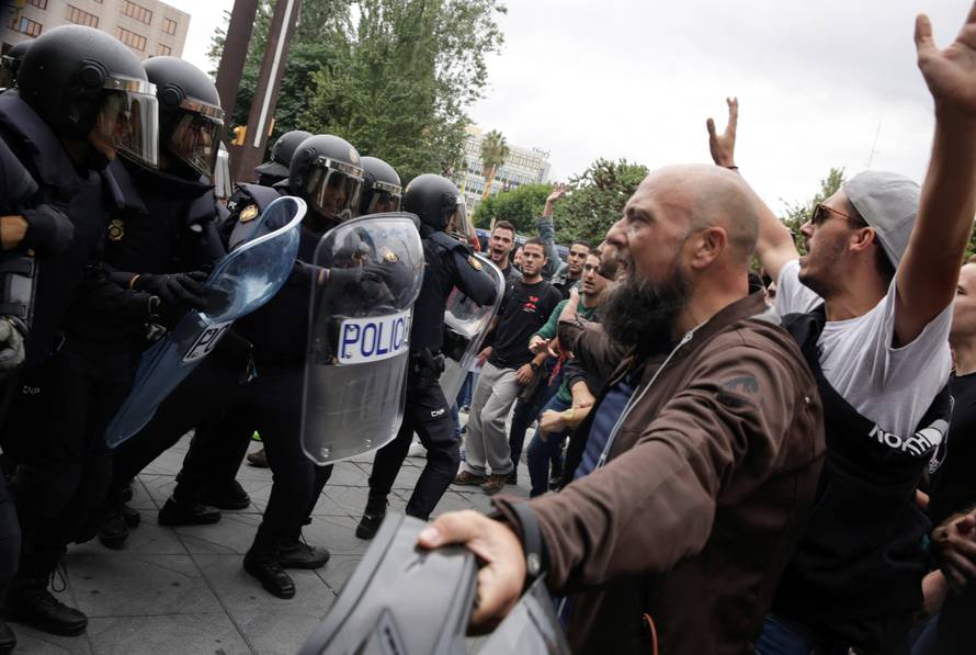 Spanish police confront people outside a polling station for the banned independence referendum in Tarragona