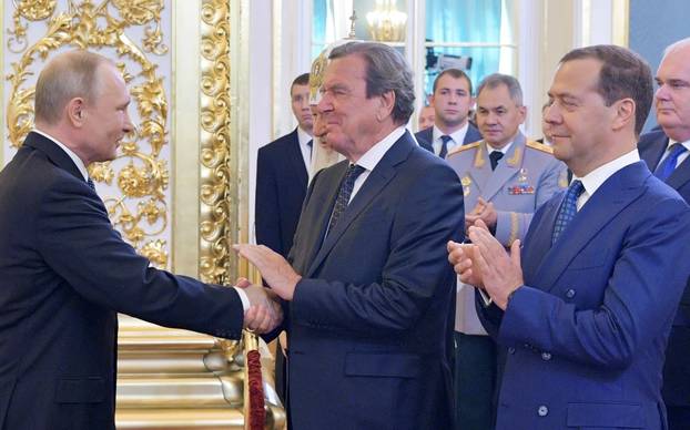 Russian Prime Minister Medvedev and German former Chancellor Schroeder greet Putin, who is sworn as Russian President during an inauguration ceremony in Moscow