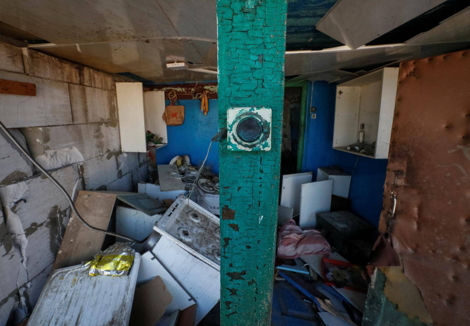 Door bell in a destroyed building is seen in a village on the front line in the east Kyiv region