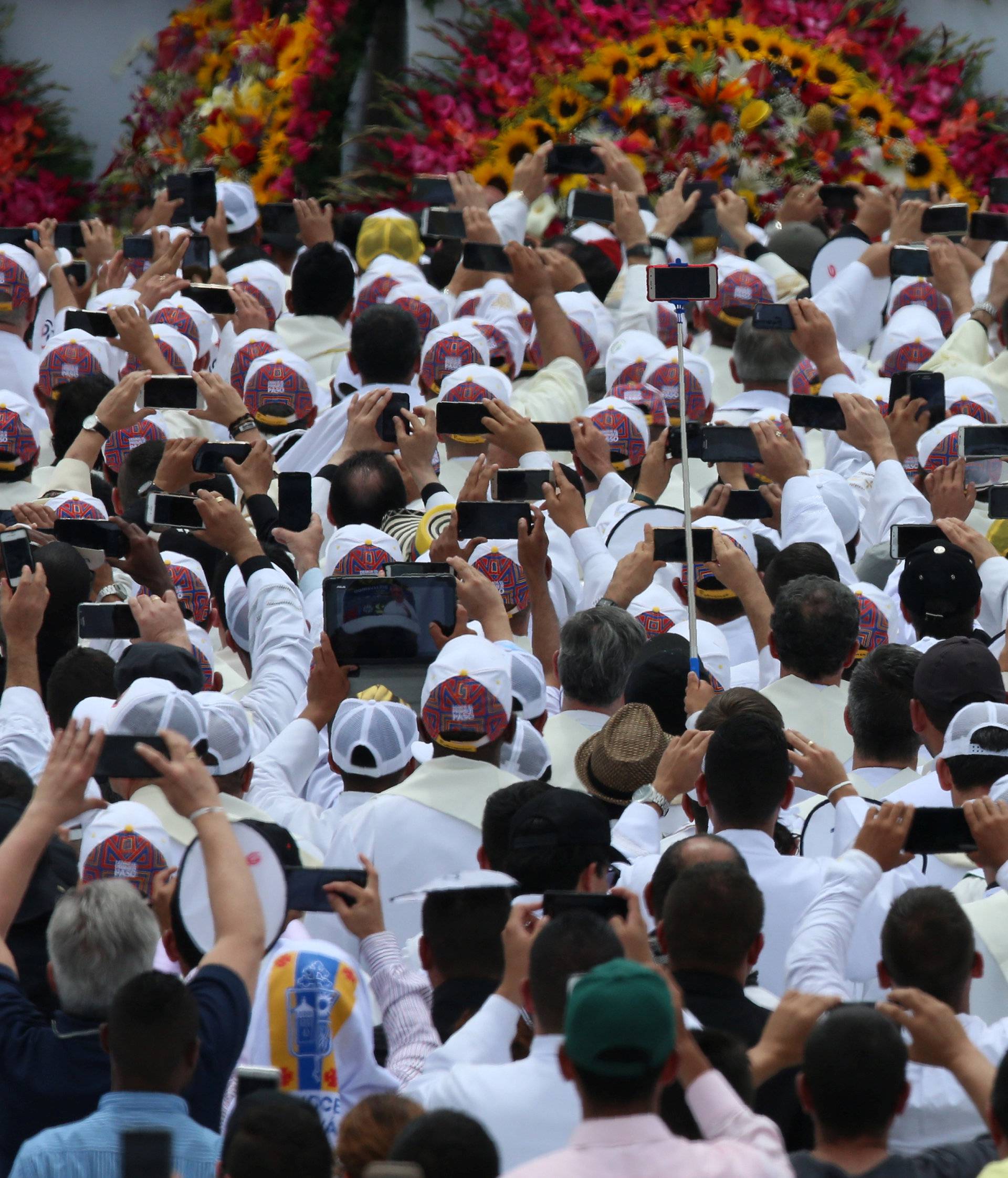 Faithful use their mobile devices as Pope Francis arrives on the popemobile for a holy mass at Enrique Olaya Herrera airport in Medellin
