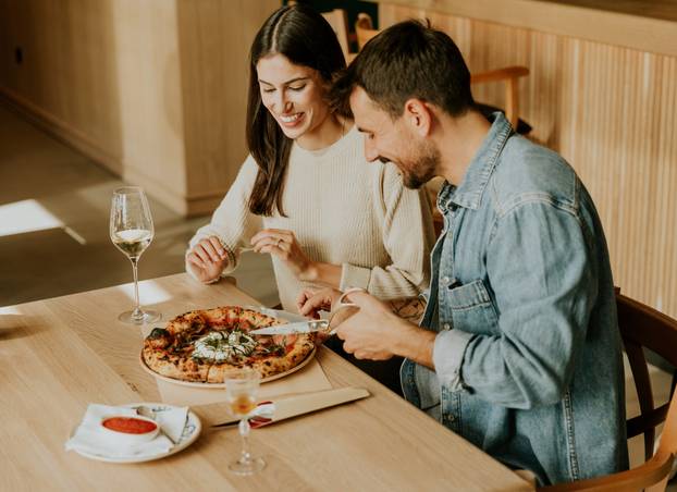 Couple enjoying a delightful meal at a cozy restaurant while sha