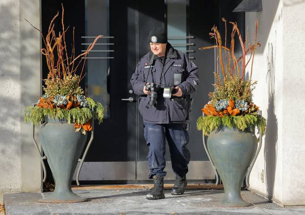 A police forensics photographer works outside the home of billionaire founder of Canadian pharmaceutical firm Apotex Inc. in Toronto