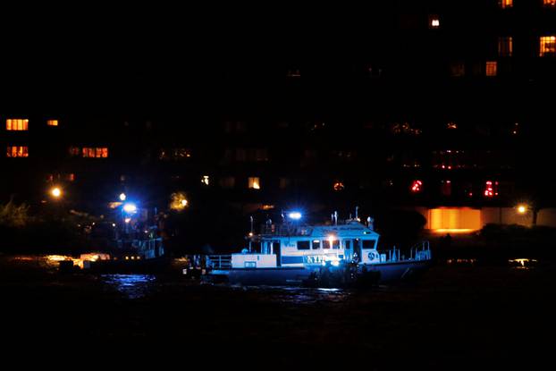 An NYPD boat searches the Hudson River for the wreckage of a vintage P-47 Thunderbolt airplane that crashed in the river in New York