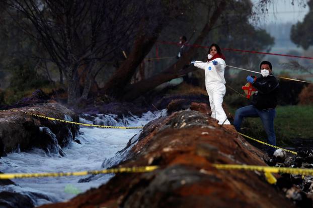 Forensic technicians work at the site where a fuel pipeline ruptured by suspected oil thieves exploded, in the municipality of Tlahuelilpan