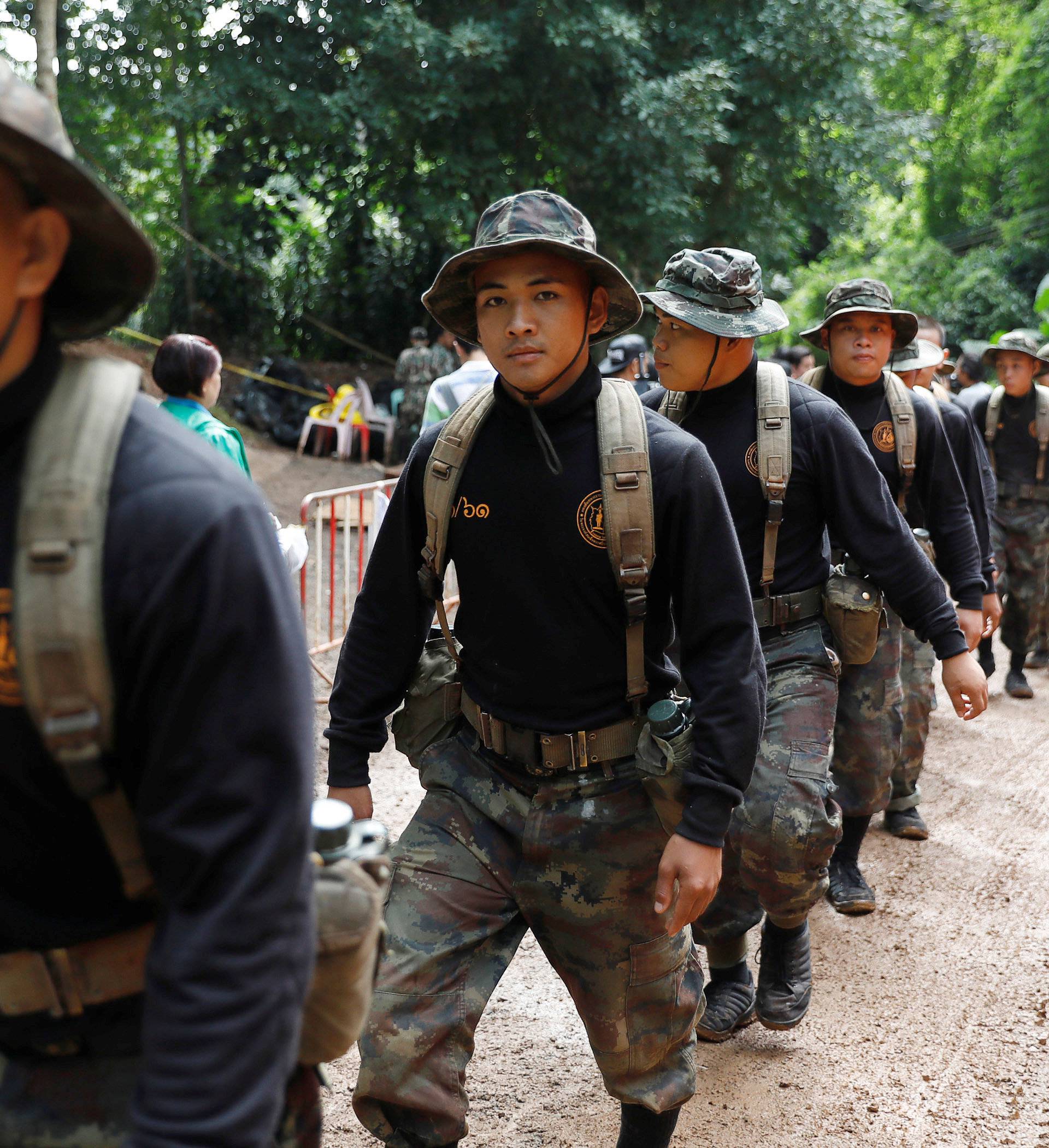 Soldiers walk near the Tham Luang cave complex, as members of an under-16 soccer team and their coach have been found alive according to local media in the northern province of Chiang Rai