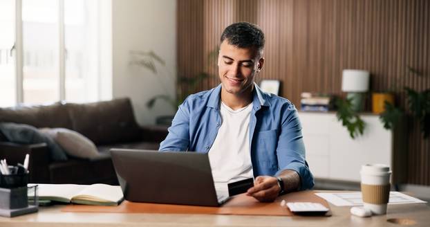 Man,,Smile,And,Credit,Card,In,Living,Room,With,Laptop,