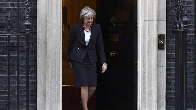 British Prime Minister Theresa May walks to greet her French counterpart Bernard Cazeneuve at Number 10 Downing Street in London