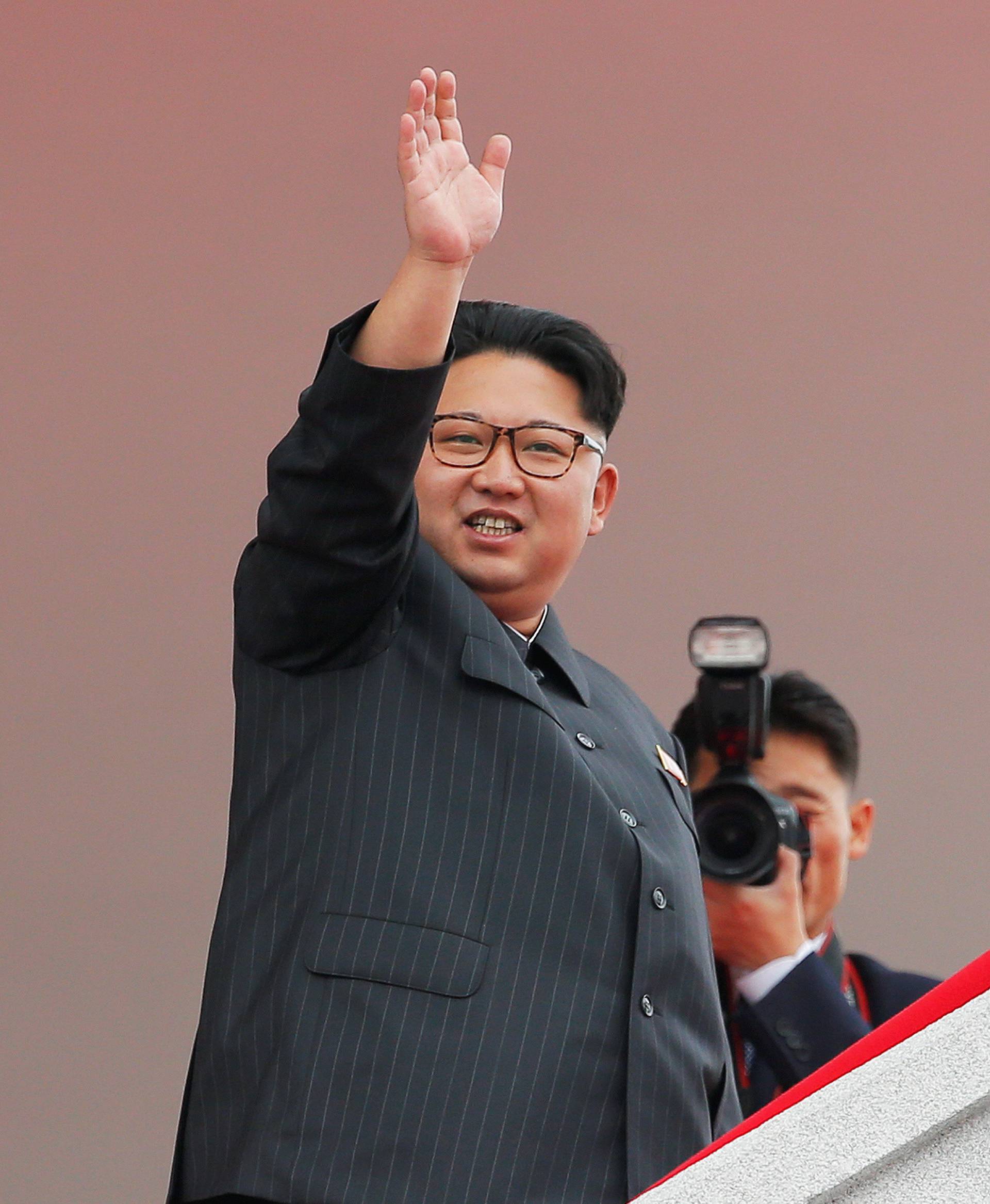 North Korean leader Kim Jong Un waves to the crowd as he presides over a mass rally and parade in Pyongyang