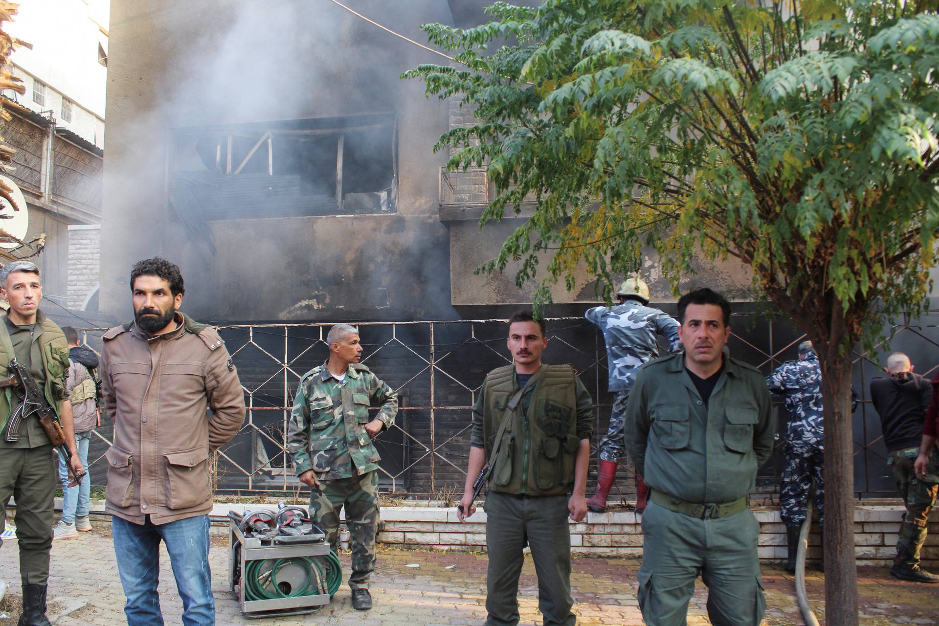 Syrian police stand near a damaged site after what Syrian state news agency said was an Israeli strike in the Damascus suburb of Mazzeh